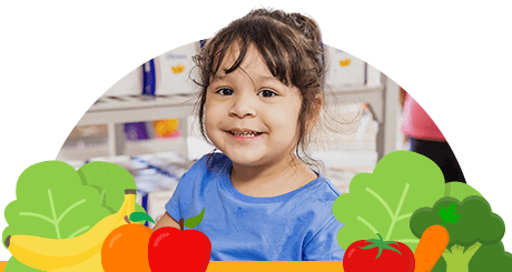 A smiling young girl in a blue shirt is surrounded by colorful cartoon vegetables and fruits.