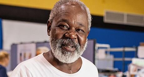 Elderly man with a white beard and gray hair, smiling kindly.